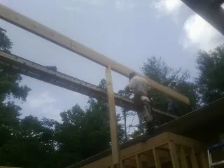 Carpenter setting a ridge beam over a new addition frame — Ice Dam Removal by Roofing Brothers in Eminence
