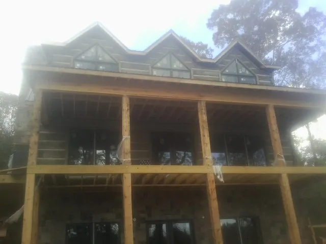 Dormers and porch framing on a large log home under construction — Roof Coating work by our crew in Eminence