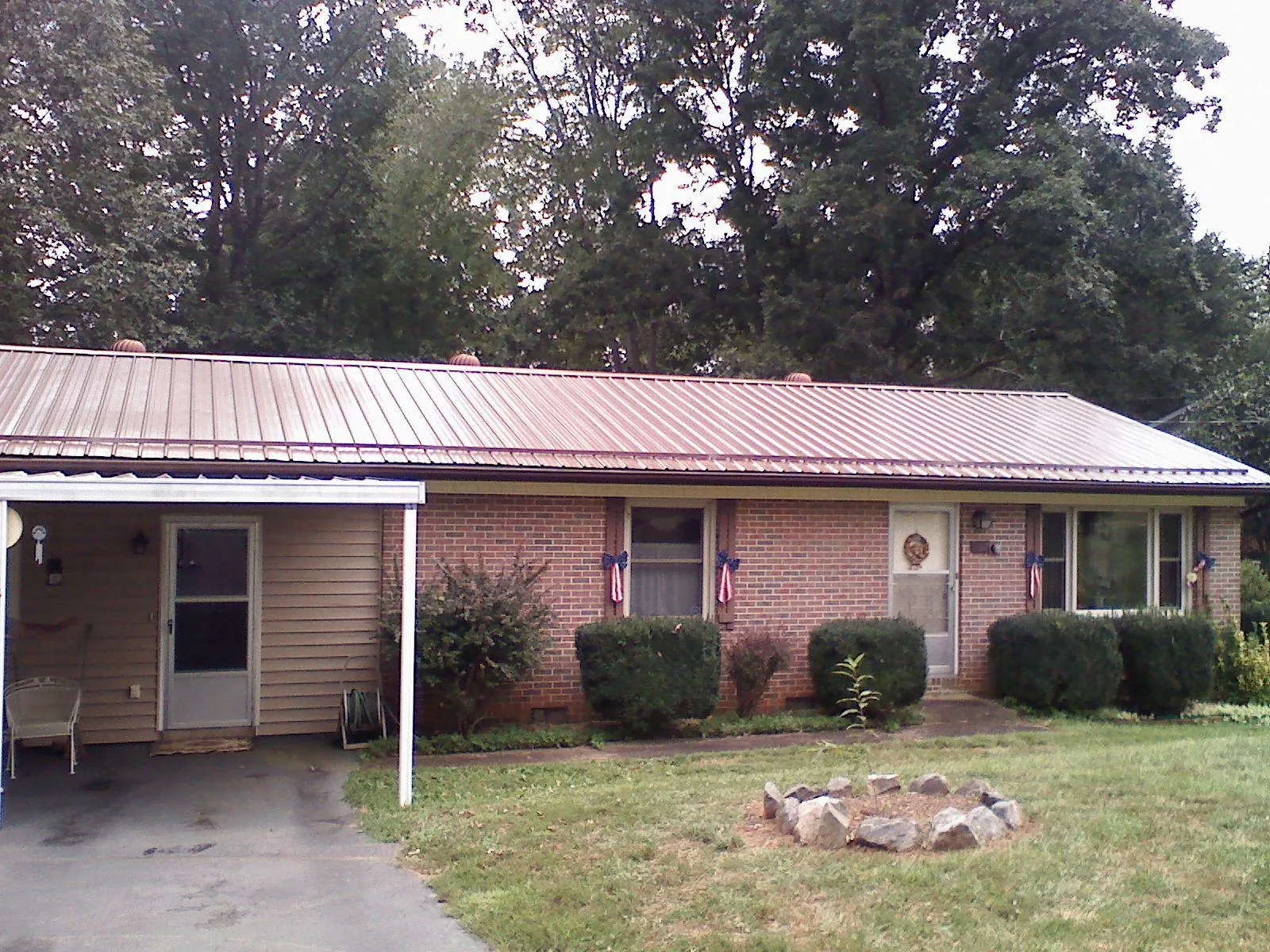 Bronze metal roof and carport on a brick ranch home — Roof Repair work by our crew in Eminence