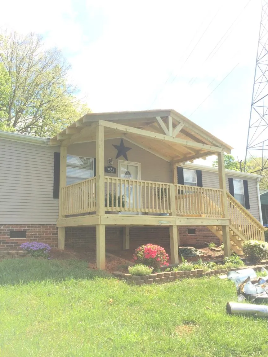 New gabled porch roof and deck railing added to a ranch home in Eminence